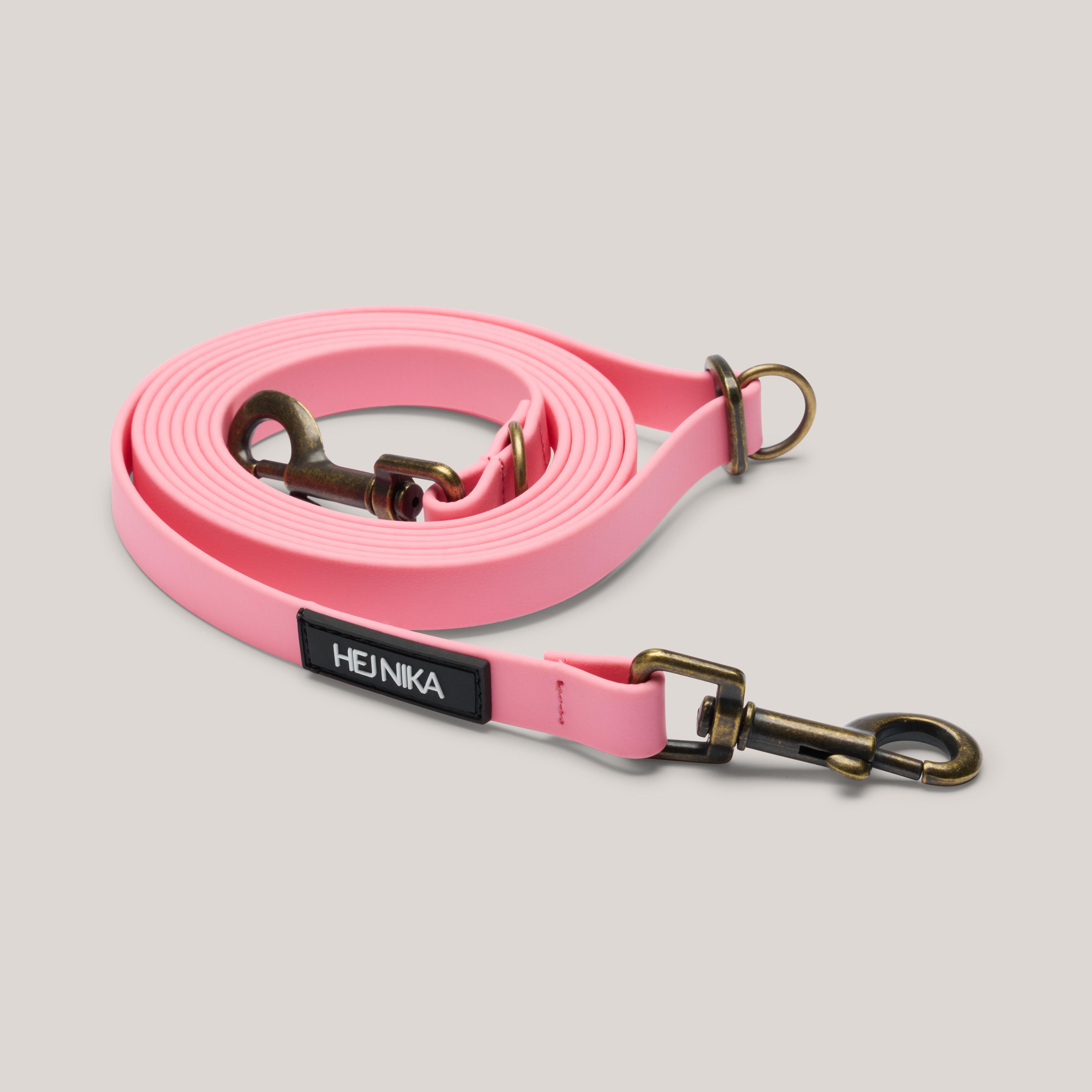 Gesamtansicht der rosa BioThane Hundeleine mit Karabinern und Schieber aus Altmessing, stufenlos verstellbar und wasserfest. Von Hej Nika.
