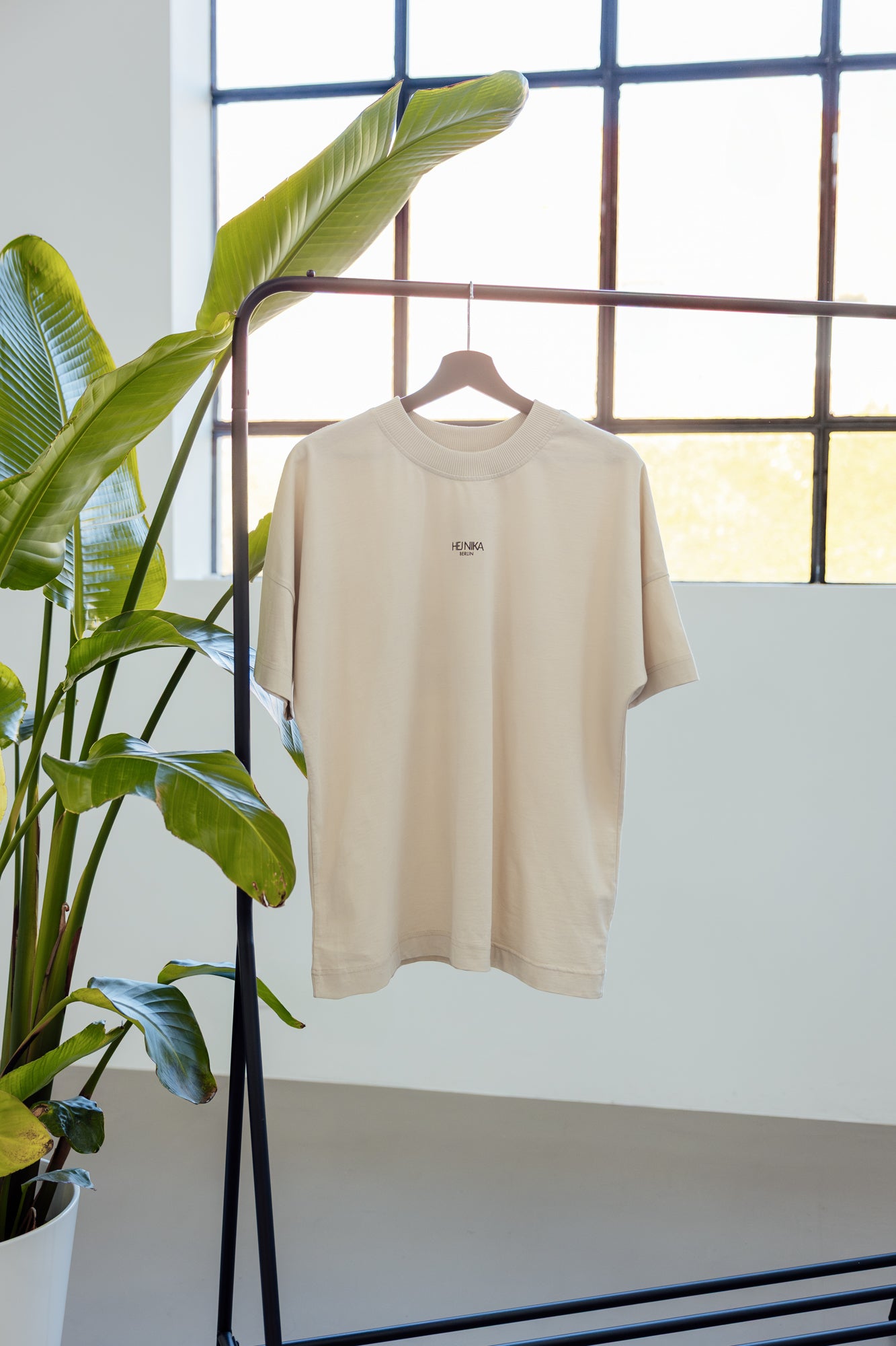 Hej Nika COFFE&DOGS T-Shirt für Hundebesitzer hängt am Kleiderbügel an einer Kleiderstange bei Studiolicht – stylisch, nachhaltig & statemnt