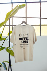 COFFEE & DOGS T-Shirt hängt drapiert an Kleiderstange – sanfter Moonbeam Ton – Hej Nika