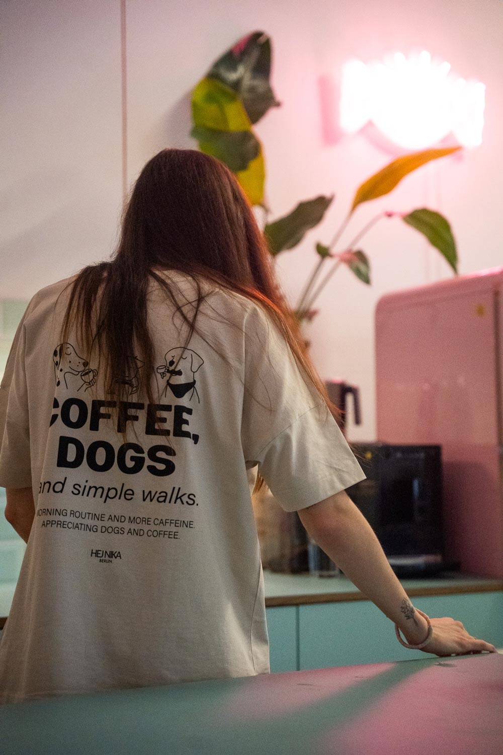 Lifestylefoto: Hundebesitzer im COFFEE & DOGS T-Shirt beim Cafébesuch mit Hund – Hej Nika