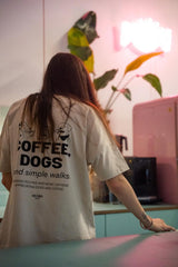 Lifestylefoto: Hundebesitzer im COFFEE & DOGS T-Shirt beim Cafébesuch mit Hund – Hej Nika