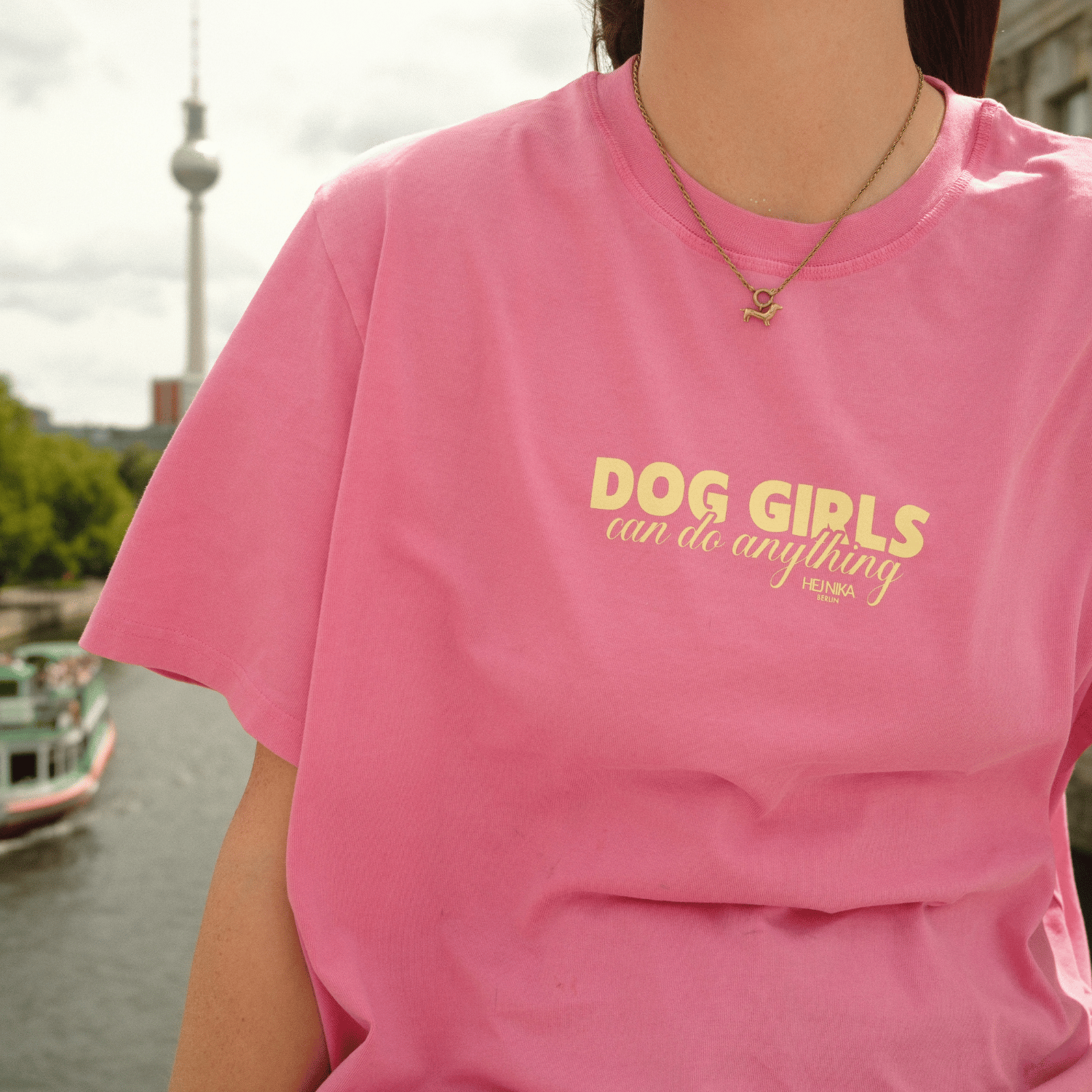 Detailansicht des pinken Hej Nika T-Shirts mit gelbem „Dog Girls Can Do Anything“-Schriftzug auf der Brust