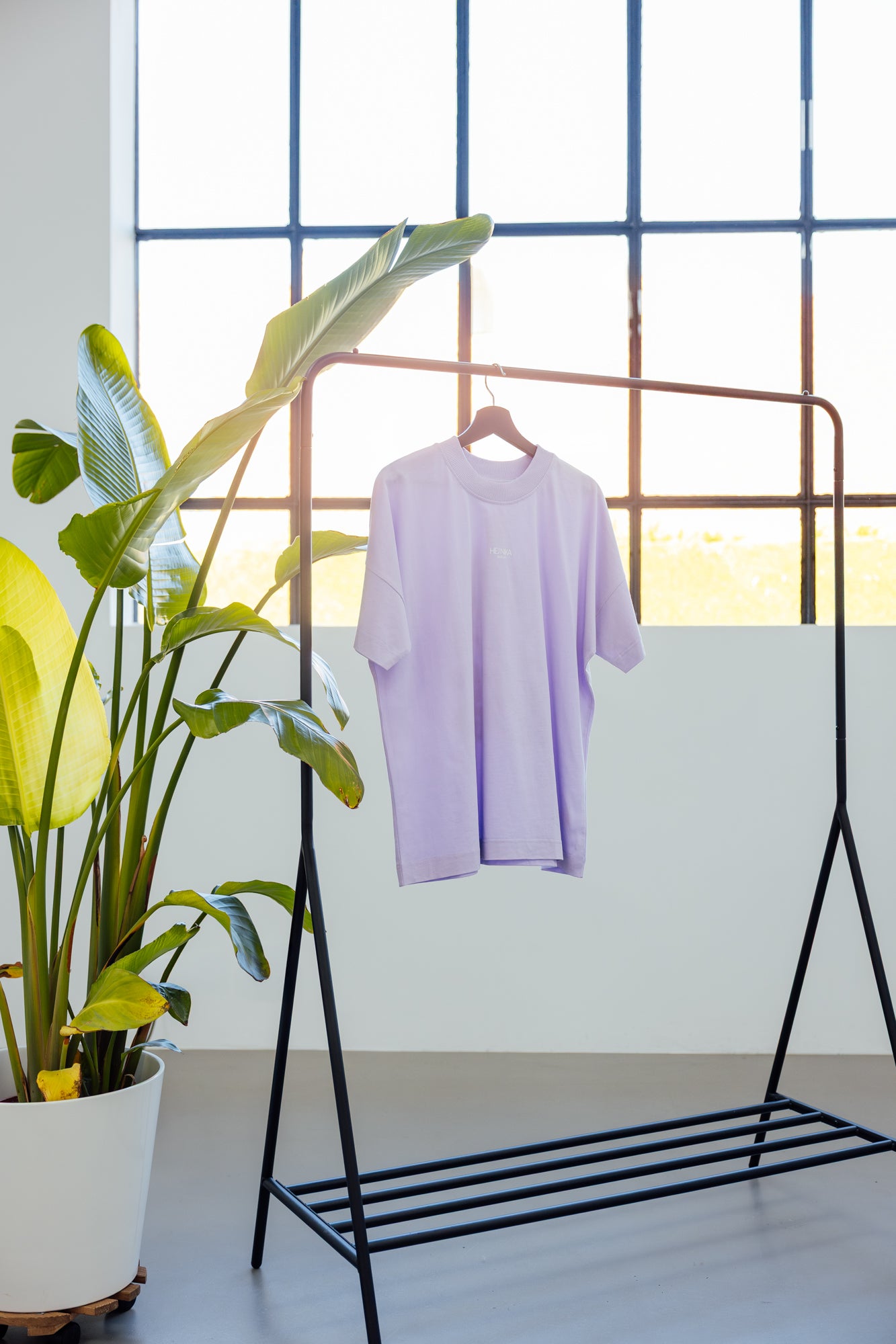 Girls Just Wanna T-Shirt in Lavendel hängt an Kleiderstange im Atelier – minimalistisches Fashion Setup – Hej Nika
