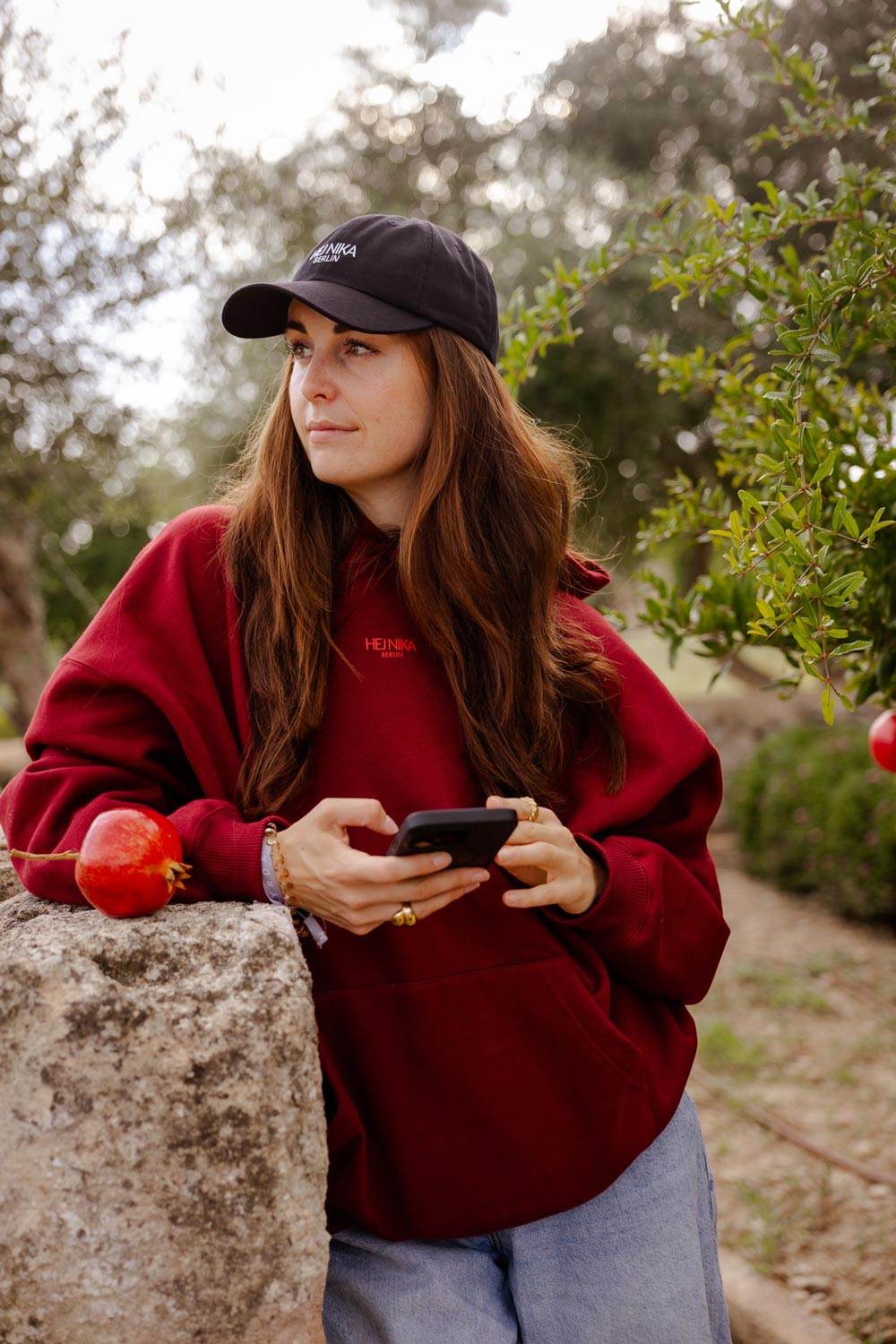 Hundebesitzerin trägt den roten Cute but Spicy Hoodie von Hej Nika beim Spaziergang – cozy, oversized & fair produziert in Portugal