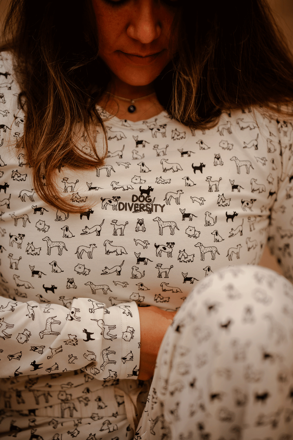 Hej Nika Pyjama Longsleeve für Hundebesitzer in Weiß. Hergestellt aus Bio-Baumwolle. Getragen von einer Hundebesitzerin an einem gemütlichen Abend. 