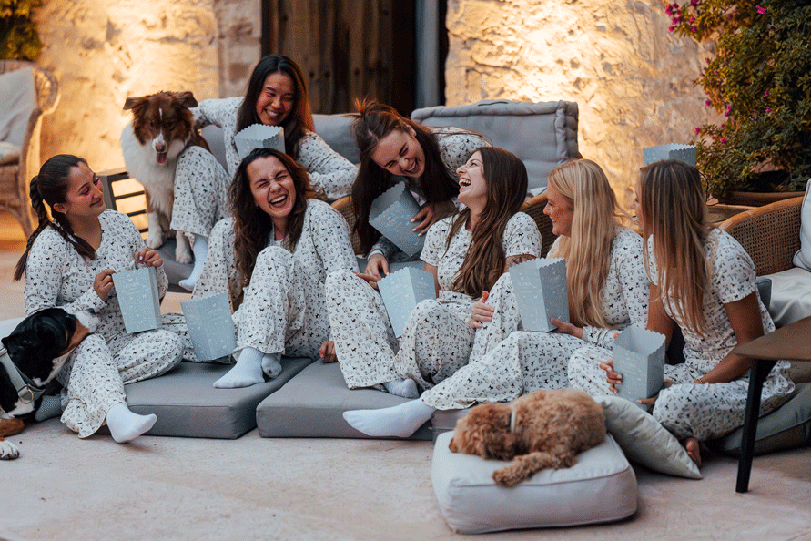 Eine Gruppe von Hundebesitzerinnen macht einen gemütlichen Kinoabend mit Hunden und trägt dabei den Hej Nika Pyjama "DOG DIVERSITY" für Hundebesitzer. 
