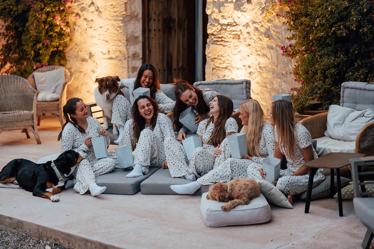 Eine Gruppe von Hundebesitzerinnen macht einen gemütlichen Kinoabend mit Hunden und trägt dabei den Hej Nika Pyjama "DOG DIVERSITY" für Hundebesitzer. 