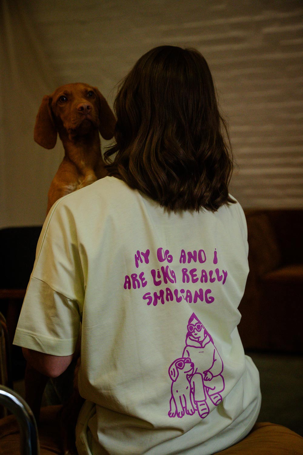 Hundebesitzer trägt Small Gang T-Shirt Lime im Café – entspannter Alltagslook – Hej Nika – T-Shirt für Hundebesitzer