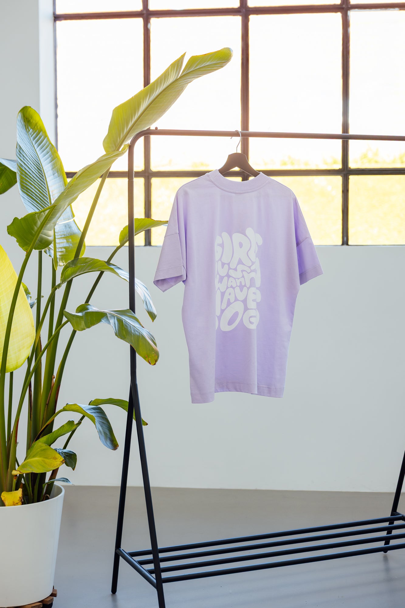 T-Shirt für Hundebesitzer "Girls Just Wanna" in einem pastell Lavendelton an einer Kleiderstange beim Shooting – 100% Bio-Baumwolle - nachhaltig, stylisch & pflegeleicht – Hej Nika