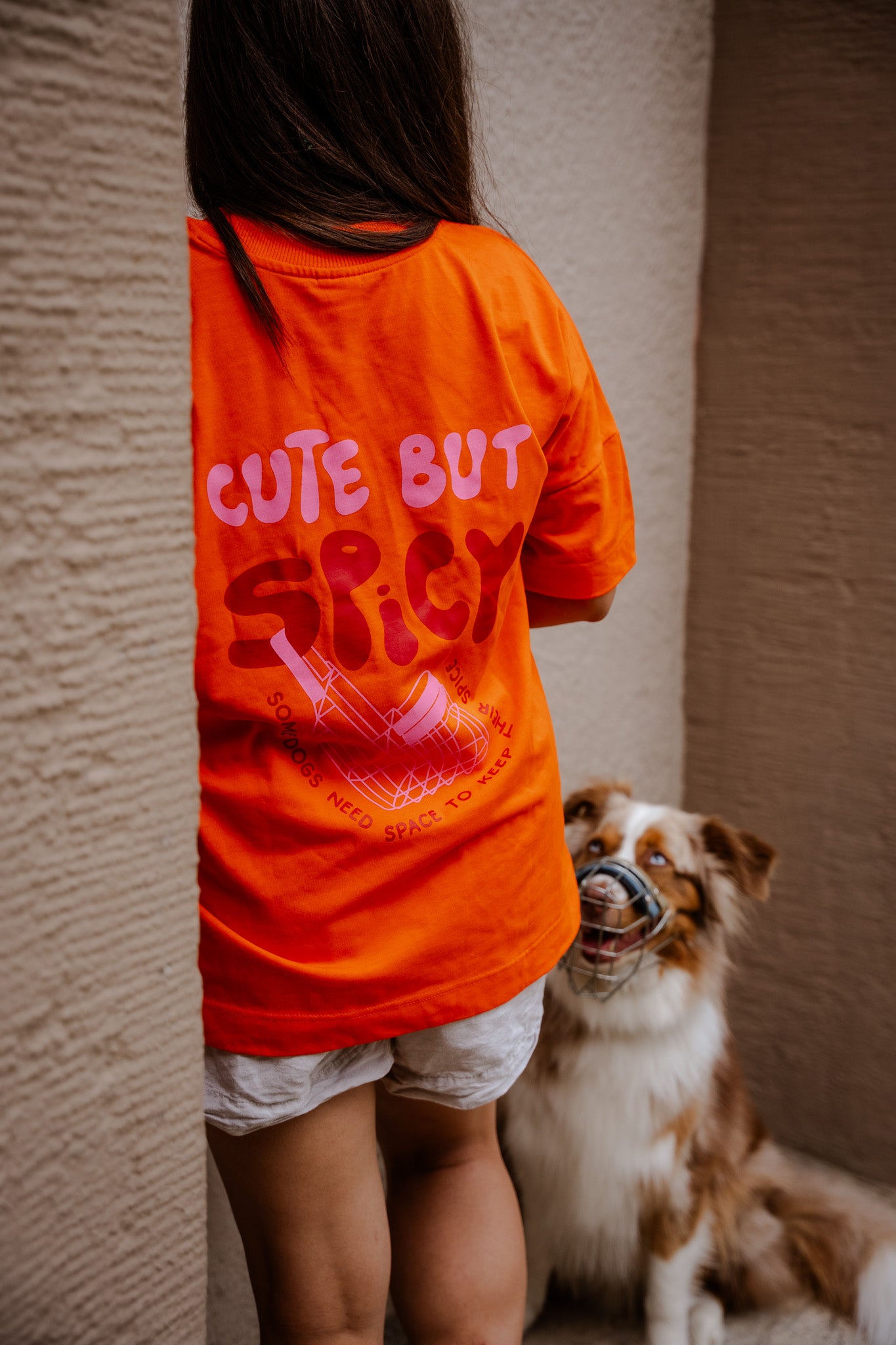 Hej Nika "Cute But Spicy" T-Shirt für Hundemenschen getragen bei einem Spaziergang mit dem Hund. Sichtbar ist der Backprint mit Statement  – Bio-Baumwolle
